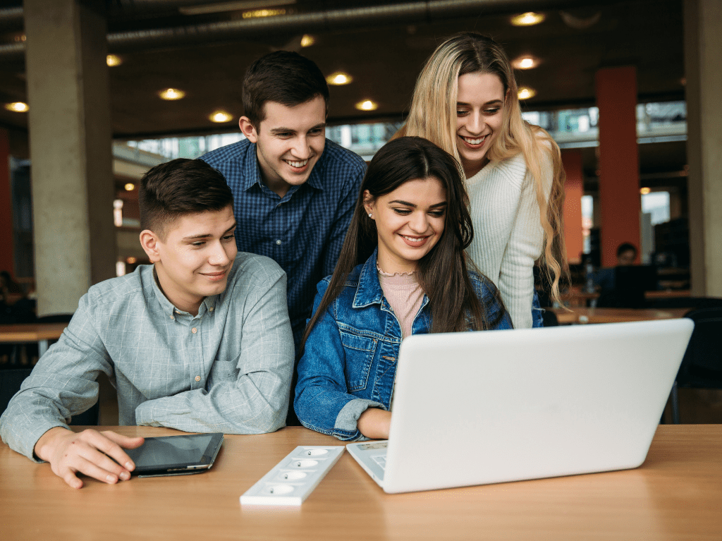 Group of co-workers working together on one device that is supported by Recast Software products.