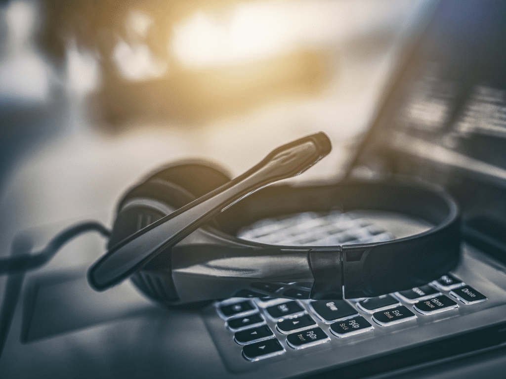 A headphone set sitting on top of a laptops keyboard.