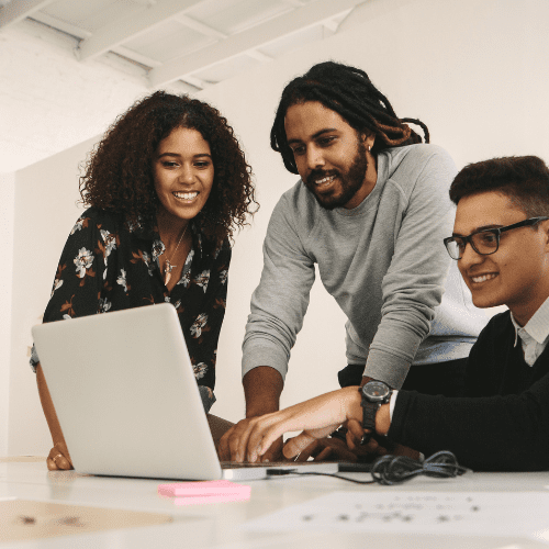 Office employees reviewing content on a computer together.